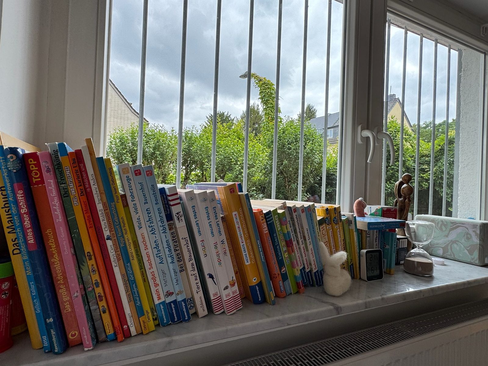 Kinderbücher auf der Fensterbank mit Blick in den Garten